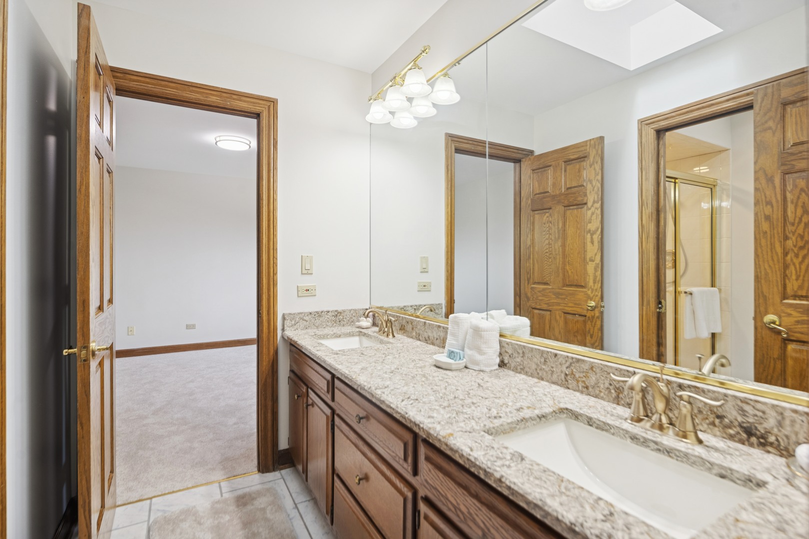 8120 Woodside Lane Burr Ridge, IL 60527 - Photo 17 of 24 a bathroom with a granite countertop double vanity sink and mirror