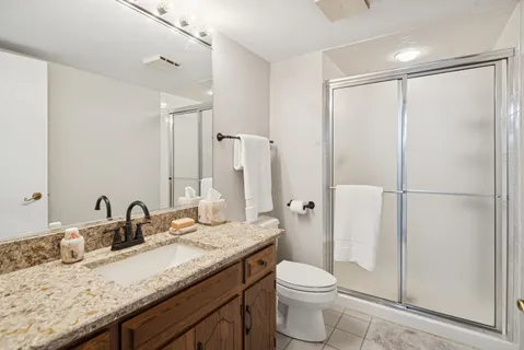 a bathroom with a granite countertop sink toilet and shower