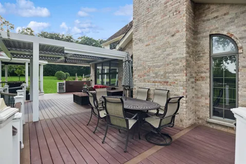 a view of a patio with table and chairs with wooden floor and fence