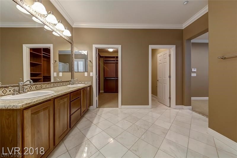 3144 Whitfeild Avenue Henderson, NV 89044 - Photo 24 of 55 Dual vanities and expansive mirrors highlight this primary bathroom, leading to organized walk-in closets.