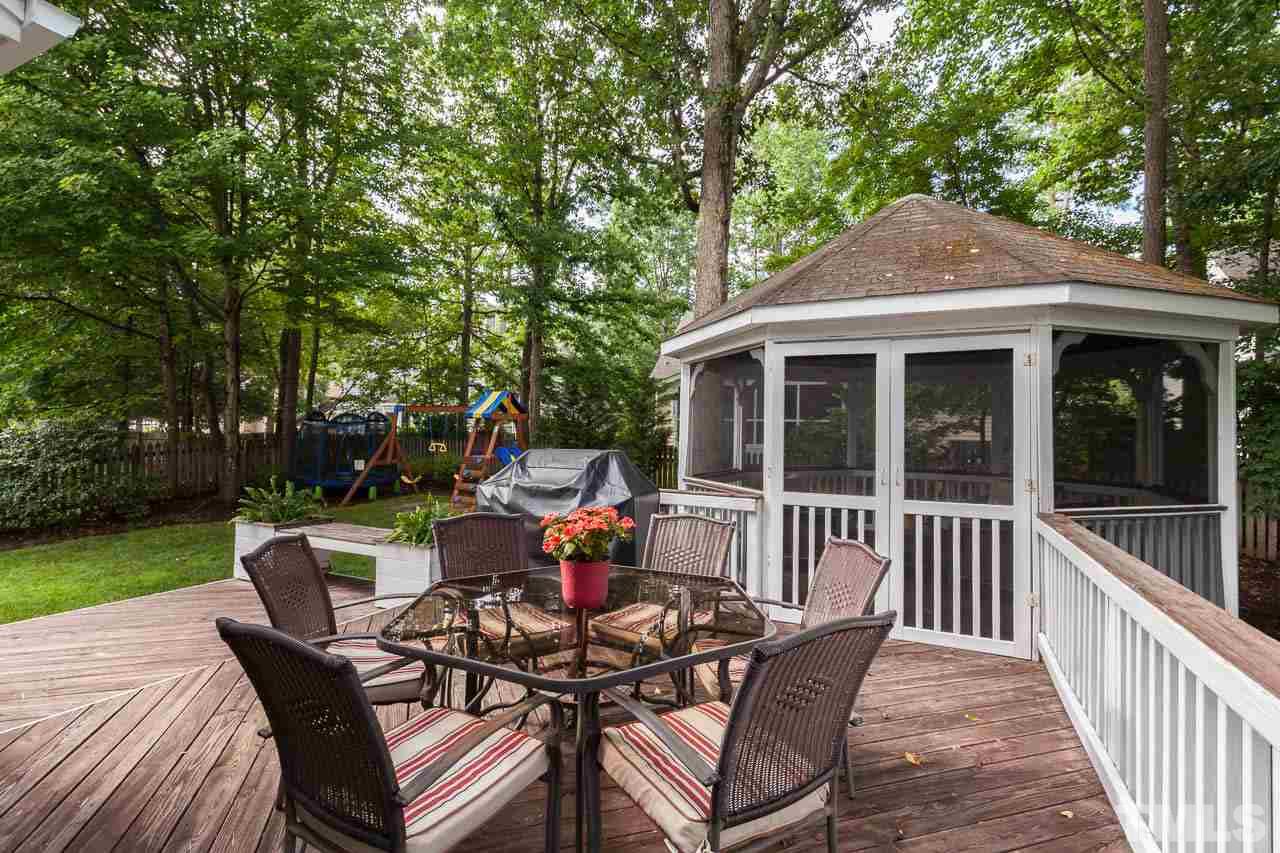 11909 Fairlie Place Raleigh, NC 27613 - Photo 22 of 25 a view of a patio with a table chairs and a yard