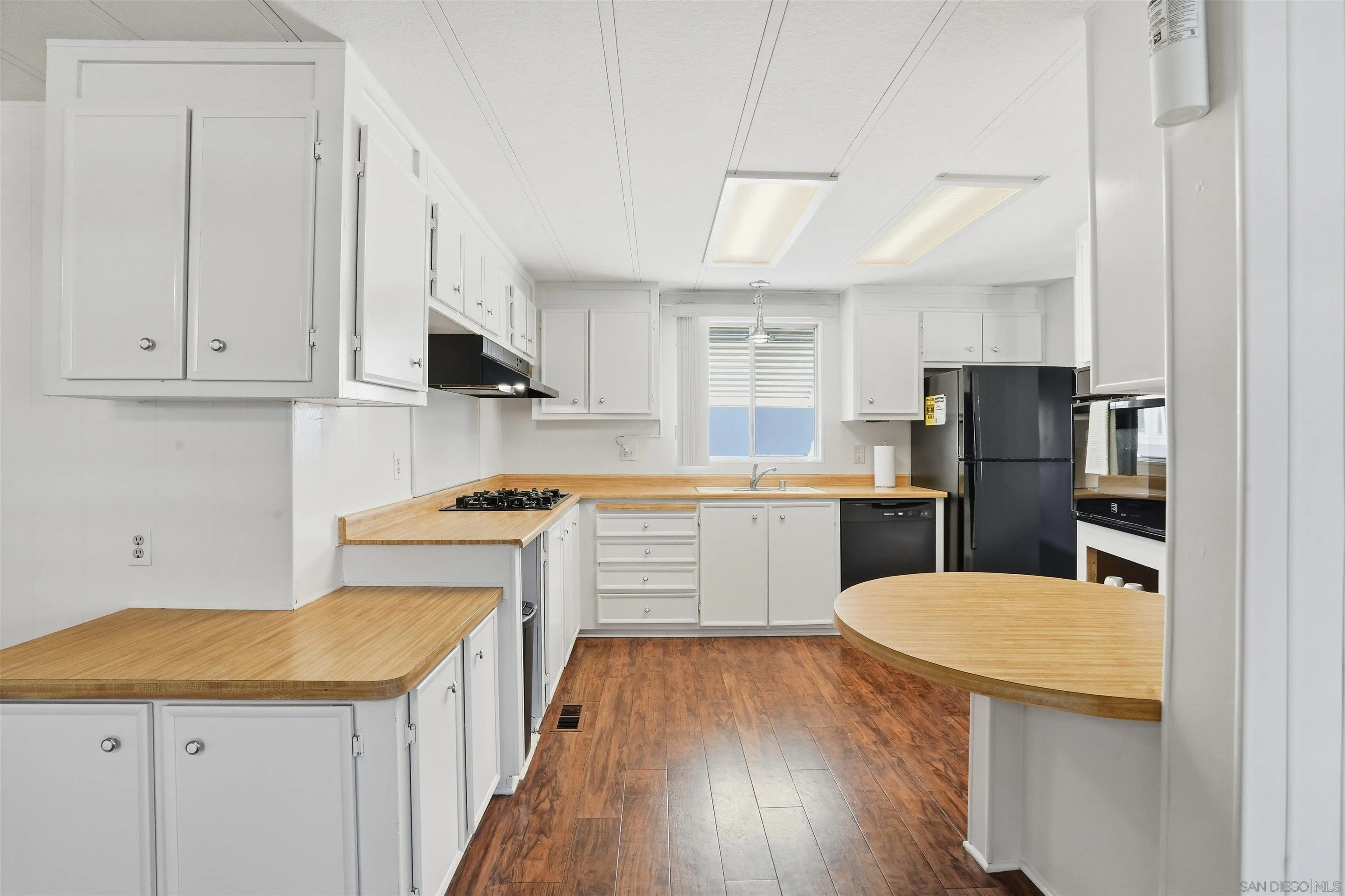 9255 North Magnolia Avenue, Unit 339 Santee, CA 92071 - Photo 12 of 55 a kitchen with a sink a stove a refrigerator and white cabinets