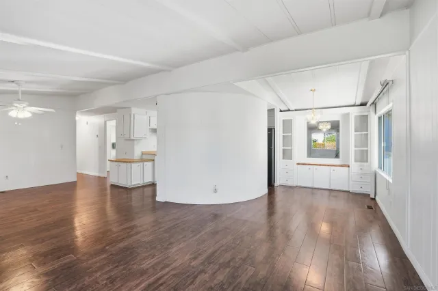 a view of empty room with wooden floor and window