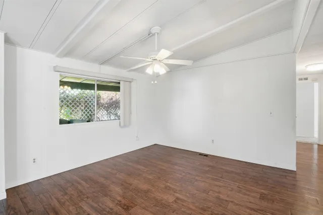 an empty room with a window and a fan