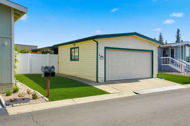 a view of a house with a patio and a yard