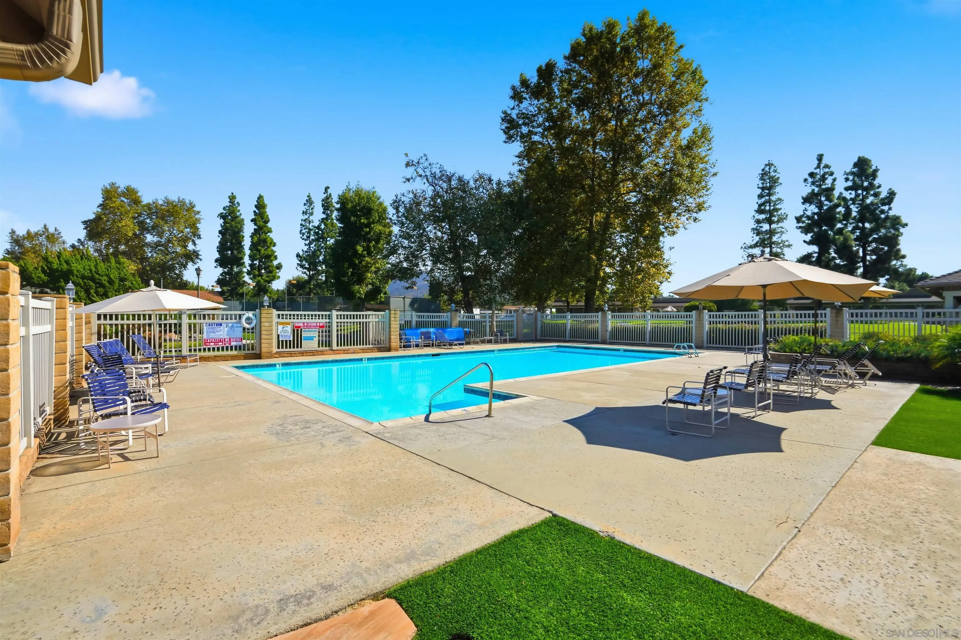 9255 North Magnolia Avenue, Unit 339 Santee, CA 92071 - Photo 45 of 55 a view of a swimming pool with lawn chairs under an umbrella