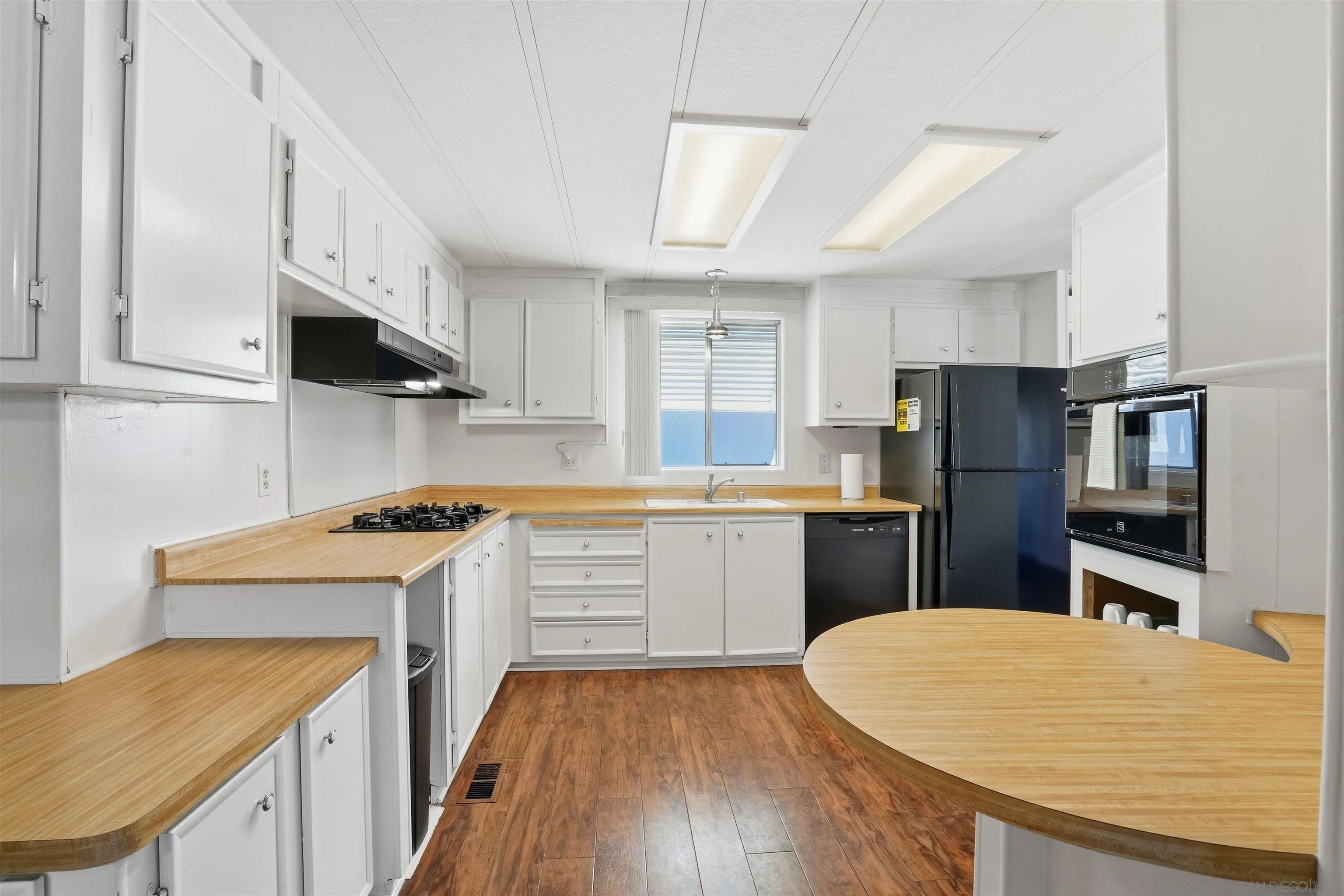 9255 North Magnolia Avenue, Unit 339 Santee, CA 92071 - Photo 5 of 55 a kitchen with a sink a stove a refrigerator cabinets and a wooden floor