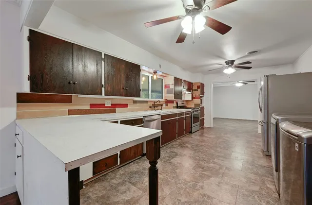 a kitchen with stainless steel appliances a stove a refrigerator and a sink