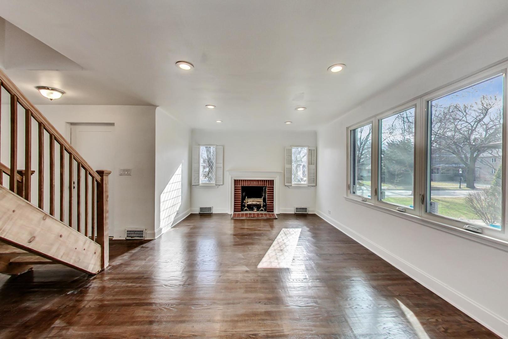 202 Lawton Road Riverside, IL 60546 - Photo 3 of 44 a view of an empty room with wooden floor fireplace and a window