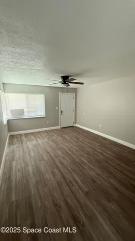 a view of empty room with wooden floor