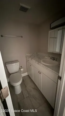 a white toilet sitting next to a sink and vanity