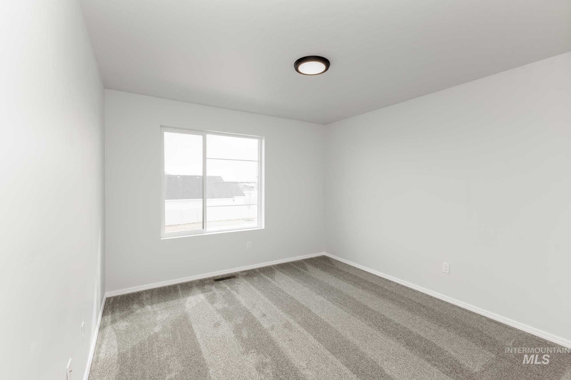 10833 Rutland Street Caldwell, ID 83605 - Photo 15 of 26 Carpeted spare room featuring baseboards