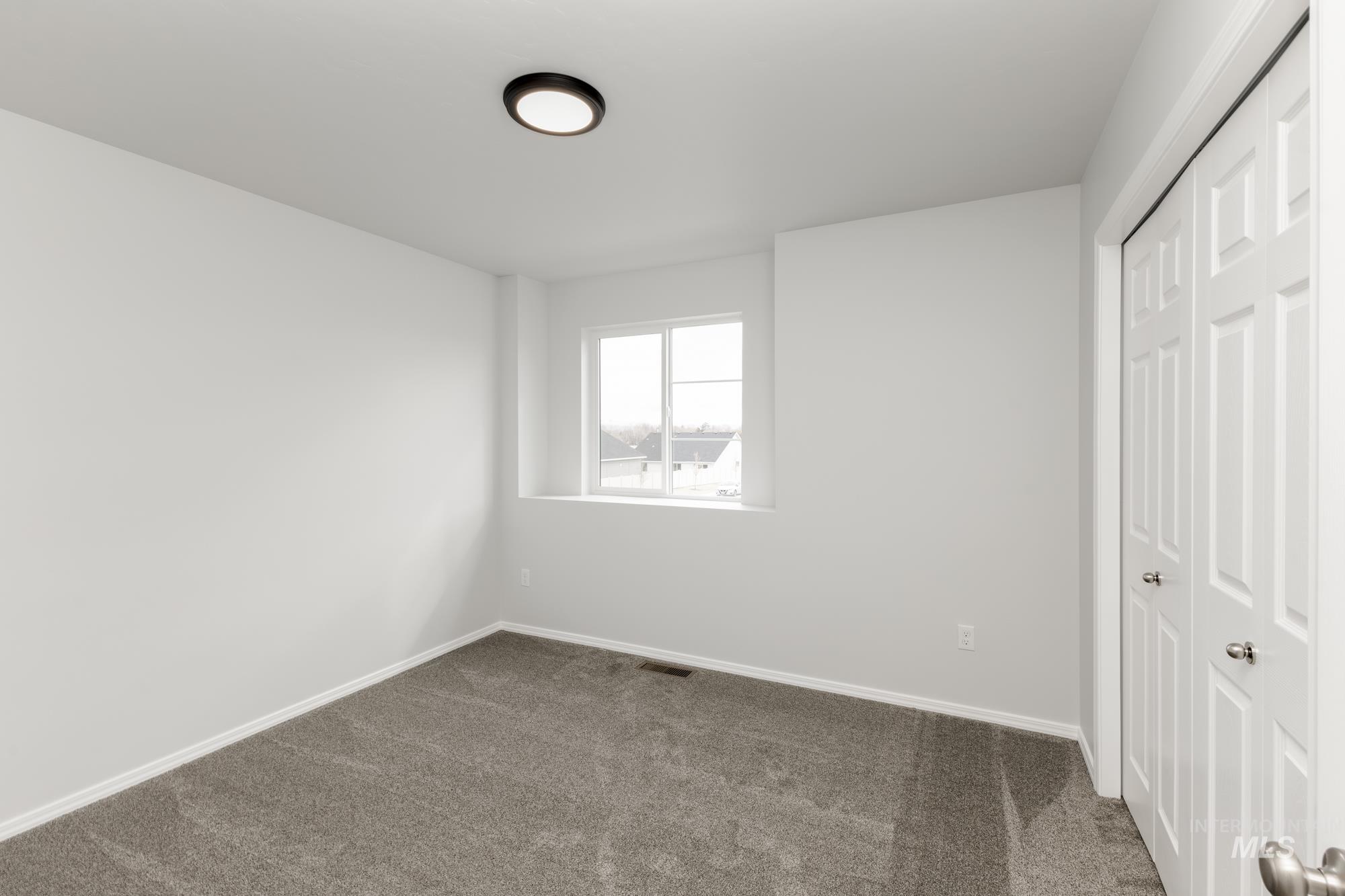 10833 Rutland Street Caldwell, ID 83605 - Photo 16 of 26 Unfurnished bedroom with a closet and dark carpet