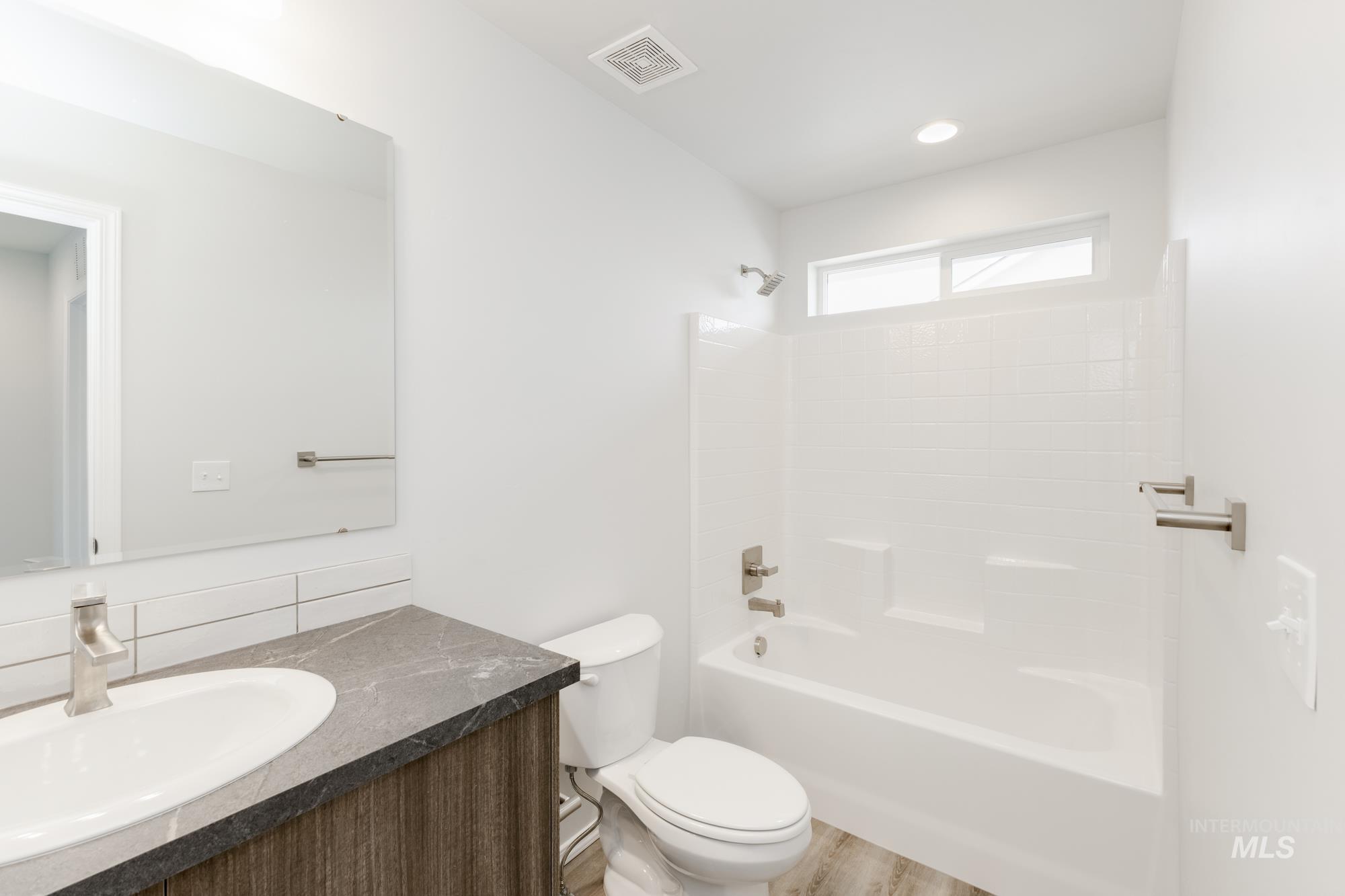 10833 Rutland Street Caldwell, ID 83605 - Photo 20 of 26 Full bath featuring vanity, bathing tub / shower combination, and light wood-style flooring
