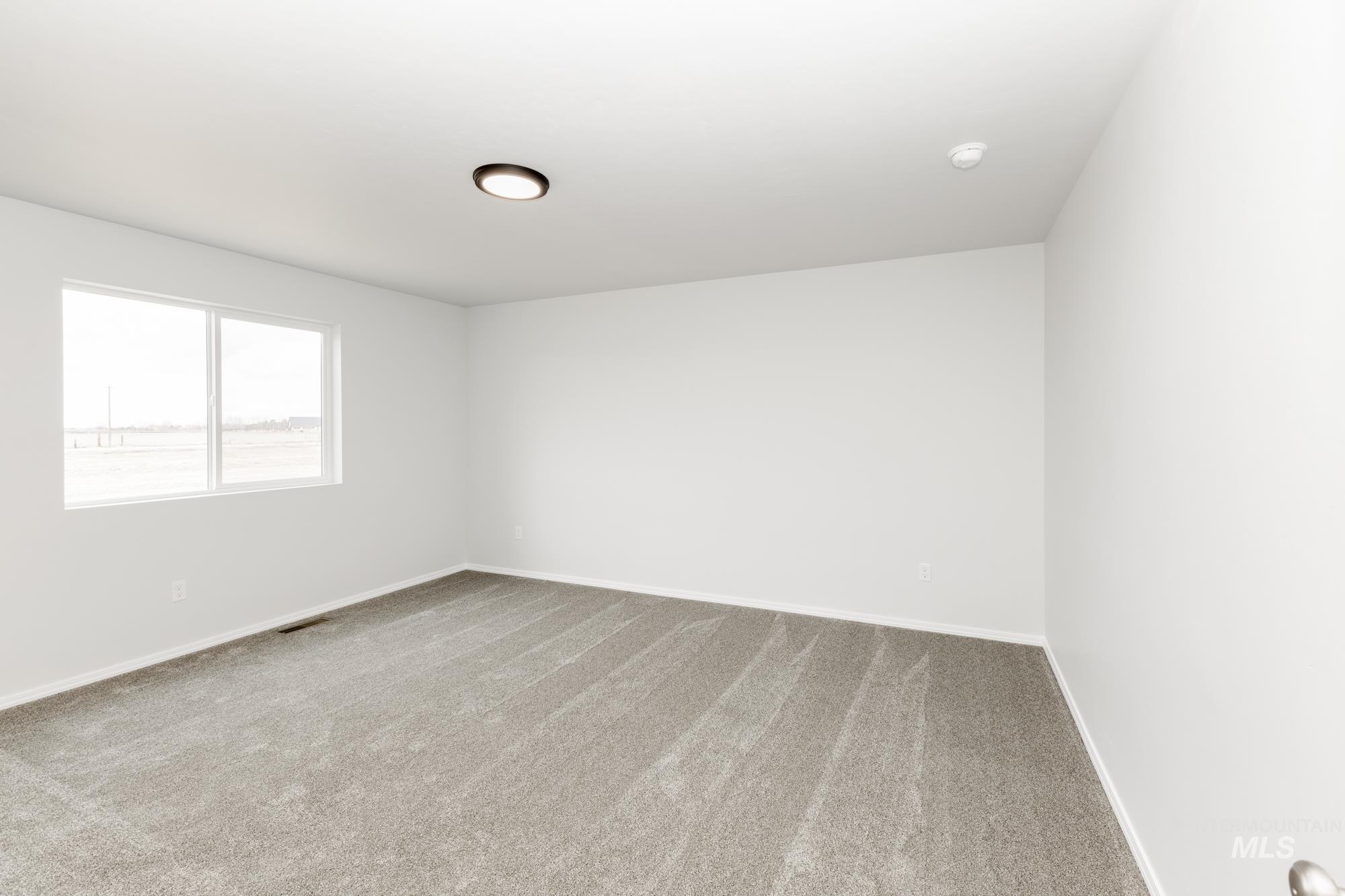 10833 Rutland Street Caldwell, ID 83605 - Photo 21 of 26 Empty room featuring light colored carpet and baseboards