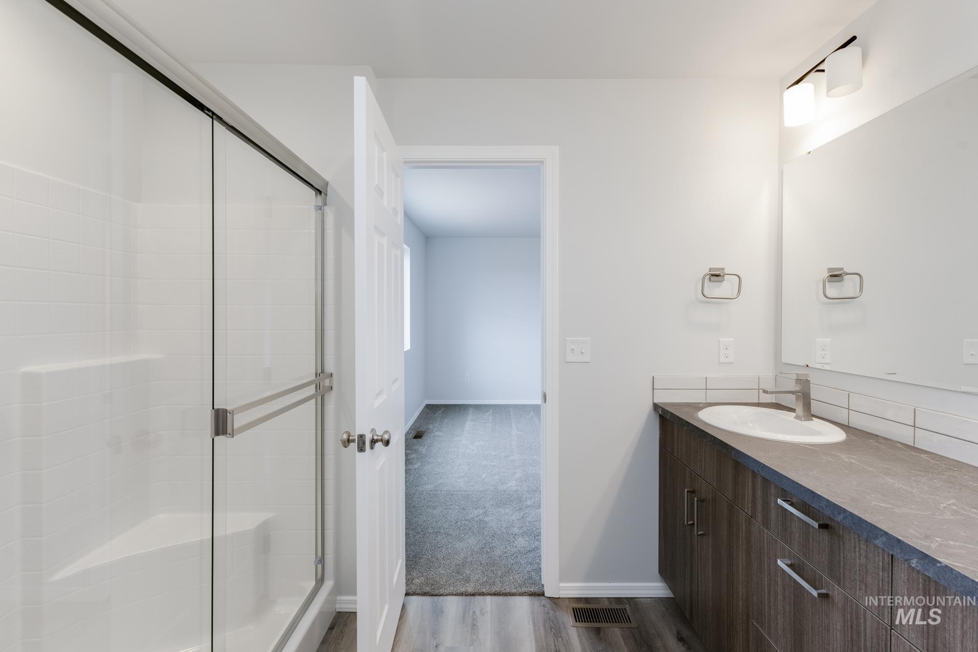10833 Rutland Street Caldwell, ID 83605 - Photo 24 of 26 Full bath with vanity, a stall shower, and dark wood finished floors