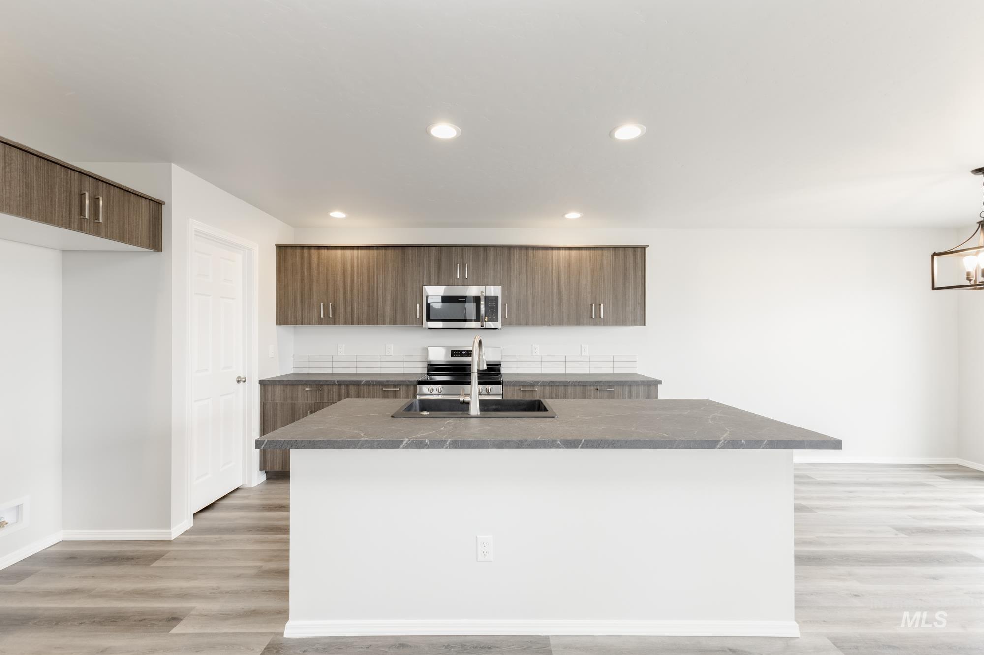 10833 Rutland Street Caldwell, ID 83605 - Photo 3 of 26 Kitchen featuring modern cabinets, stainless steel appliances, a center island with sink, light wood finished floors, and recessed lighting