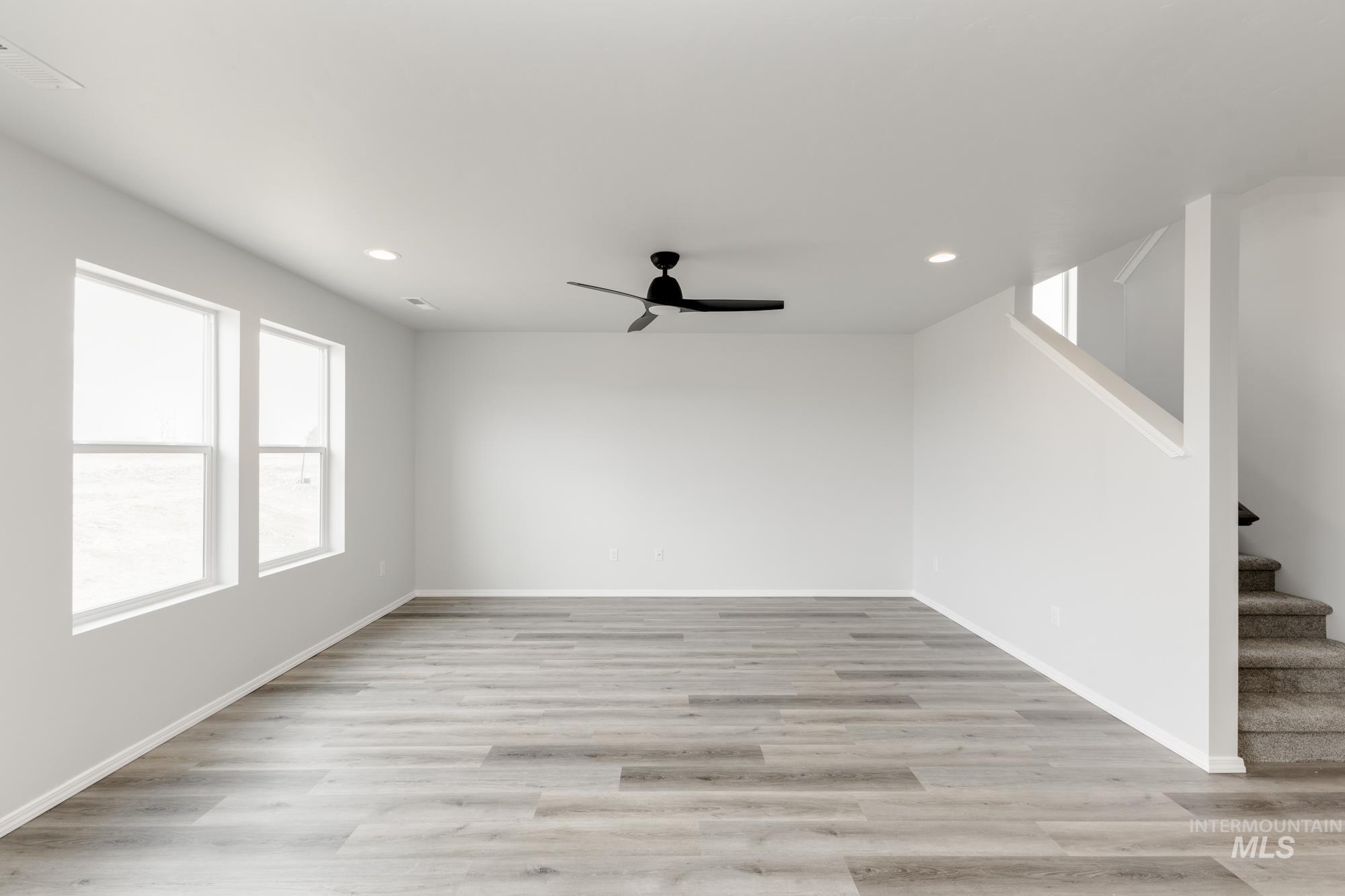 10833 Rutland Street Caldwell, ID 83605 - Photo 8 of 26 Unfurnished living room featuring ceiling fan, light wood finished floors, stairway, and recessed lighting