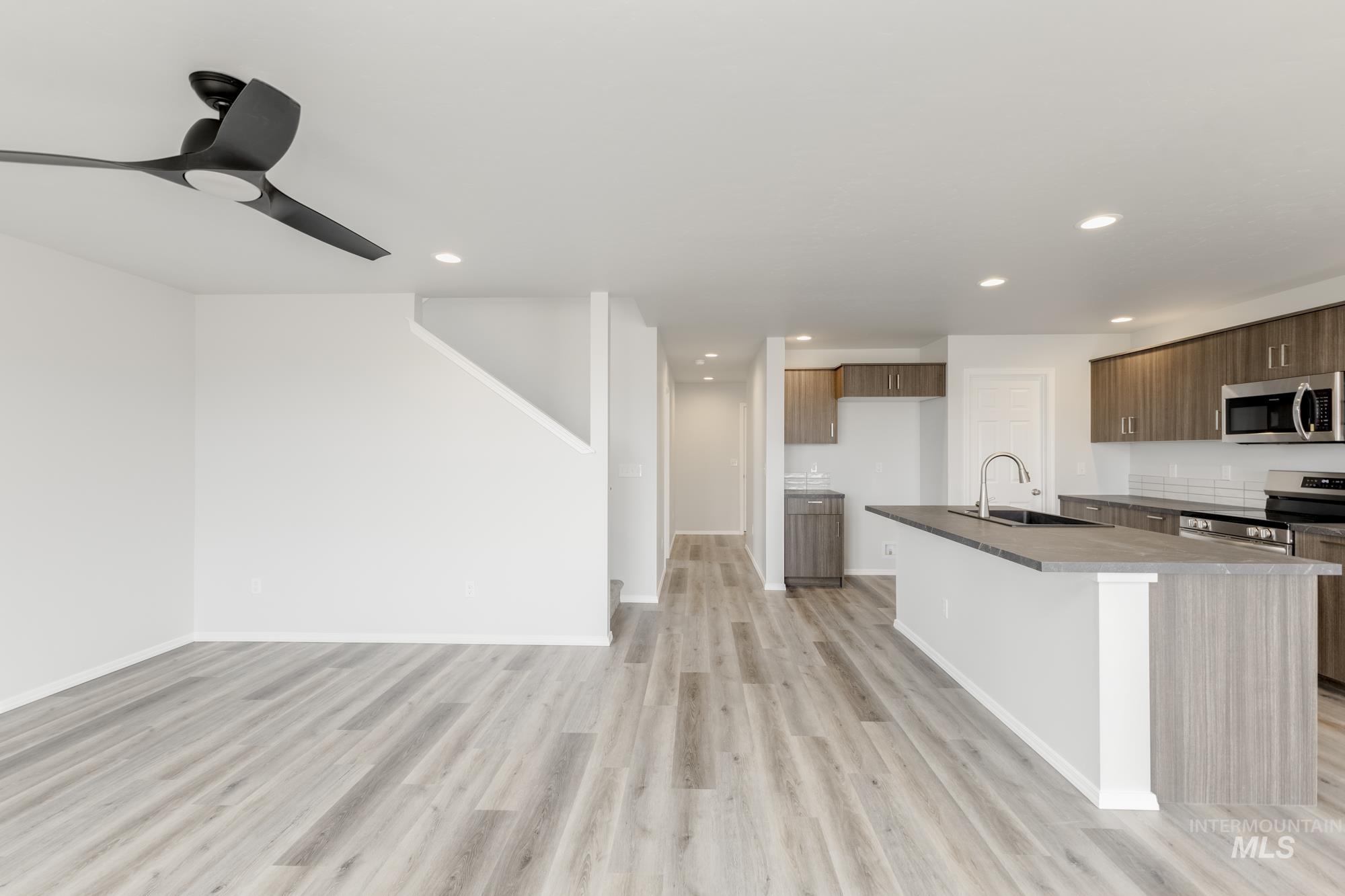 10833 Rutland Street Caldwell, ID 83605 - Photo 9 of 26 Kitchen with stainless steel appliances, light wood-style flooring, modern cabinets, an island with sink, and ceiling fan