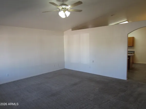a view of an empty room with a chandelier fan