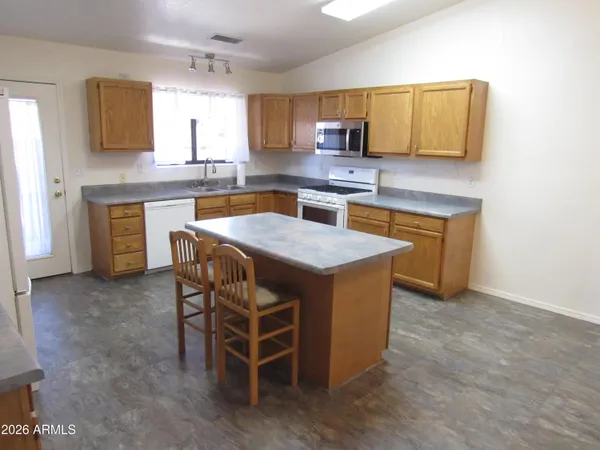 a kitchen with stainless steel appliances granite countertop a sink a stove a microwave a counter top space and cabinets