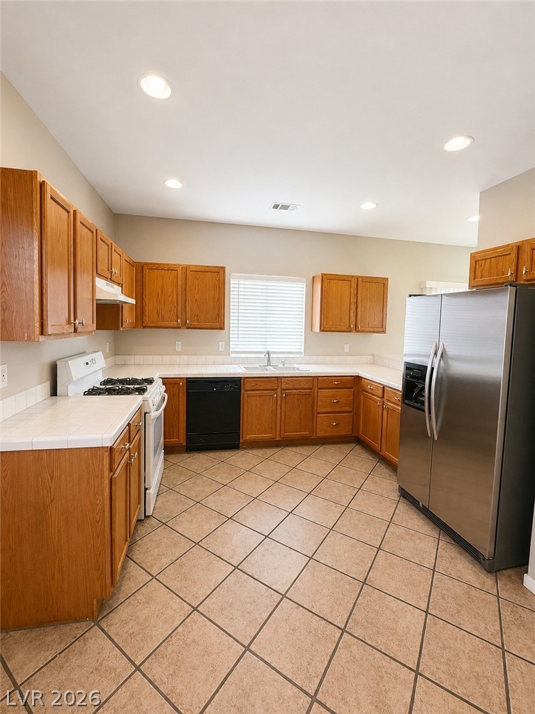 7213 London Bridge Avenue Las Vegas, NV 89130 - Photo 4 of 11 This spacious kitchen features ample cabinetry and durable flooring for everyday living.