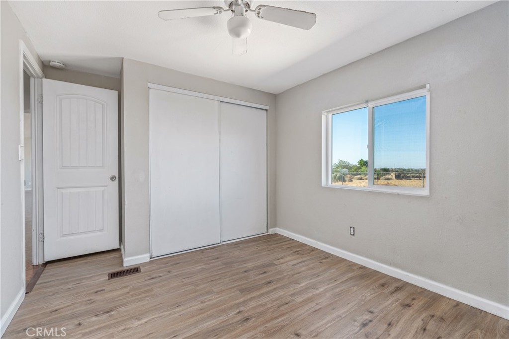 6320 Cholame Road Phelan, CA 92371 - Photo 23 of 33 an empty room with wooden floor and windows
