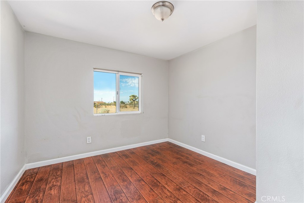 6320 Cholame Road Phelan, CA 92371 - Photo 25 of 33 an empty room with wooden floor and windows
