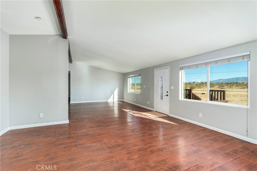 6320 Cholame Road Phelan, CA 92371 - Photo 7 of 33 an empty room with wooden floor and windows