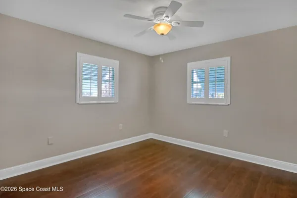a view of an empty room with wooden floor