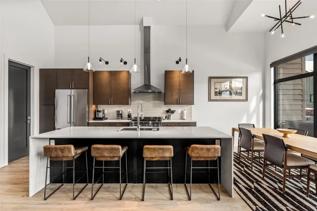 a kitchen with stainless steel appliances a table and chairs in it