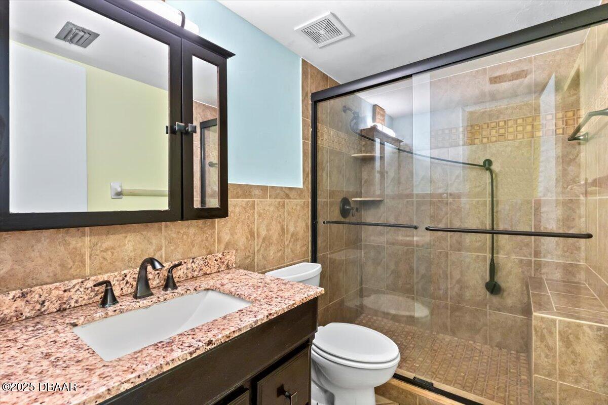 640 North Nova Road, Unit 114 Ormond Beach, FL 32174 - Photo 14 of 40 a bathroom with a granite countertop sink toilet and shower