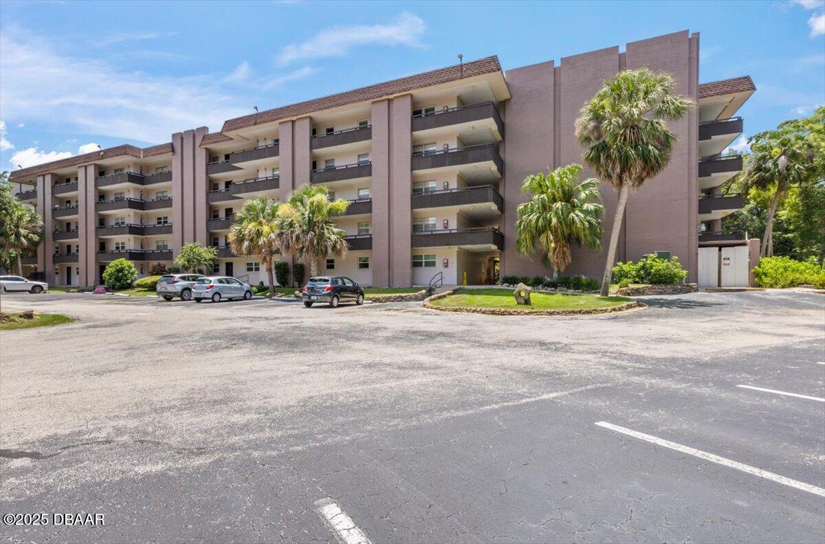 640 North Nova Road, Unit 114 Ormond Beach, FL 32174 - Photo 38 of 40 a front view of multi story residential apartment building with yard and traffic signal