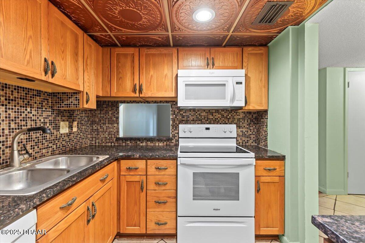640 North Nova Road, Unit 114 Ormond Beach, FL 32174 - Photo 6 of 40 a kitchen with granite countertop a sink and a stove next to a window