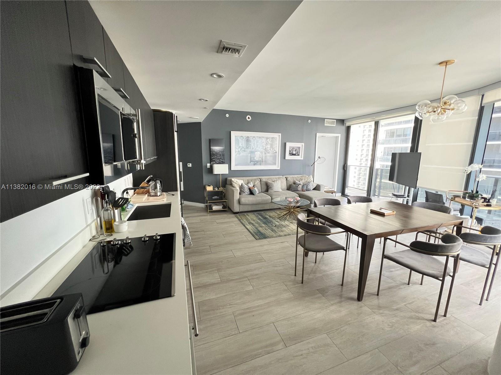 45 Southwest 9th Street, Unit 1908 Miami, FL 33130 - Photo 19 of 51 a living room with couches a computer on desk and chair