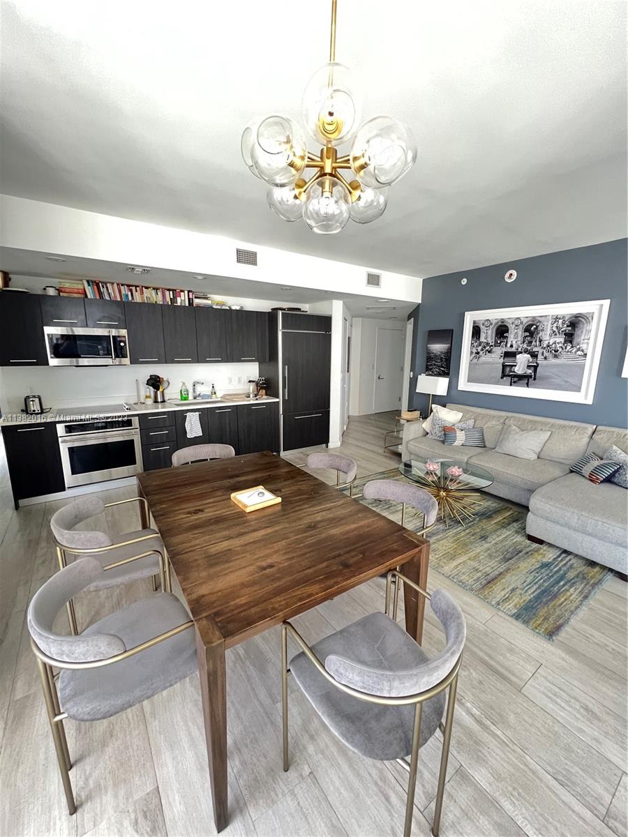 45 Southwest 9th Street, Unit 1908 Miami, FL 33130 - Photo 22 of 51 a living room with furniture and a chandelier