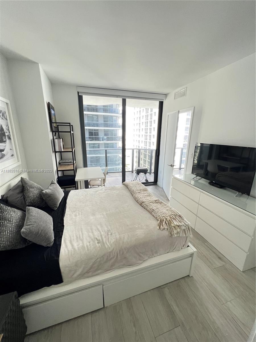 45 Southwest 9th Street, Unit 1908 Miami, FL 33130 - Photo 40 of 51 a large bed sitting in a bedroom next to a window and a couch