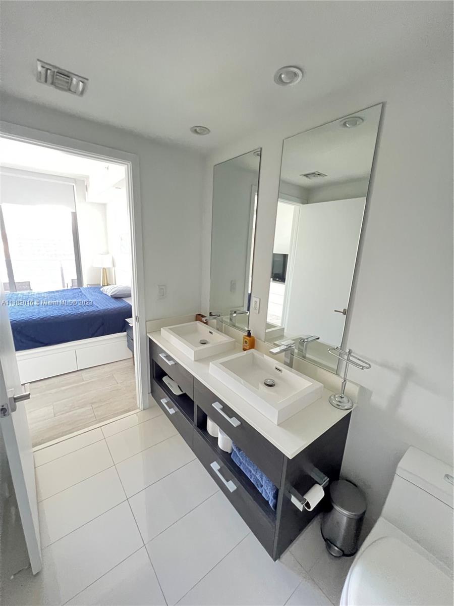 45 Southwest 9th Street, Unit 1908 Miami, FL 33130 - Photo 41 of 51 a bathroom with a sink and a mirror