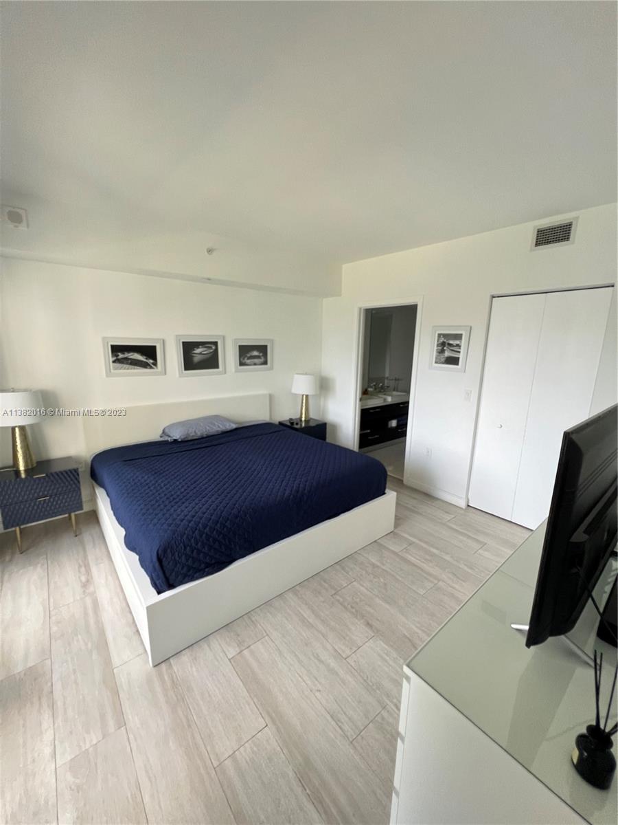 45 Southwest 9th Street, Unit 1908 Miami, FL 33130 - Photo 45 of 51 a spacious bedroom with a bed and a flat screen television