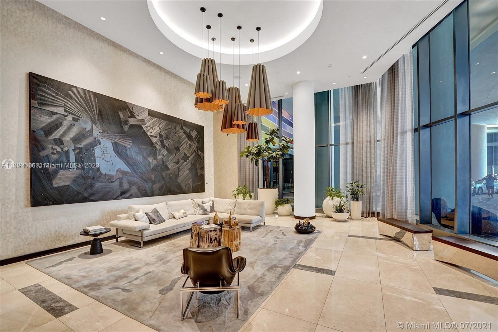 45 Southwest 9th Street, Unit 1908 Miami, FL 33130 - Photo 7 of 51 a living room with furniture and a flat screen tv