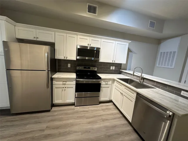 a kitchen with a refrigerator sink and stove
