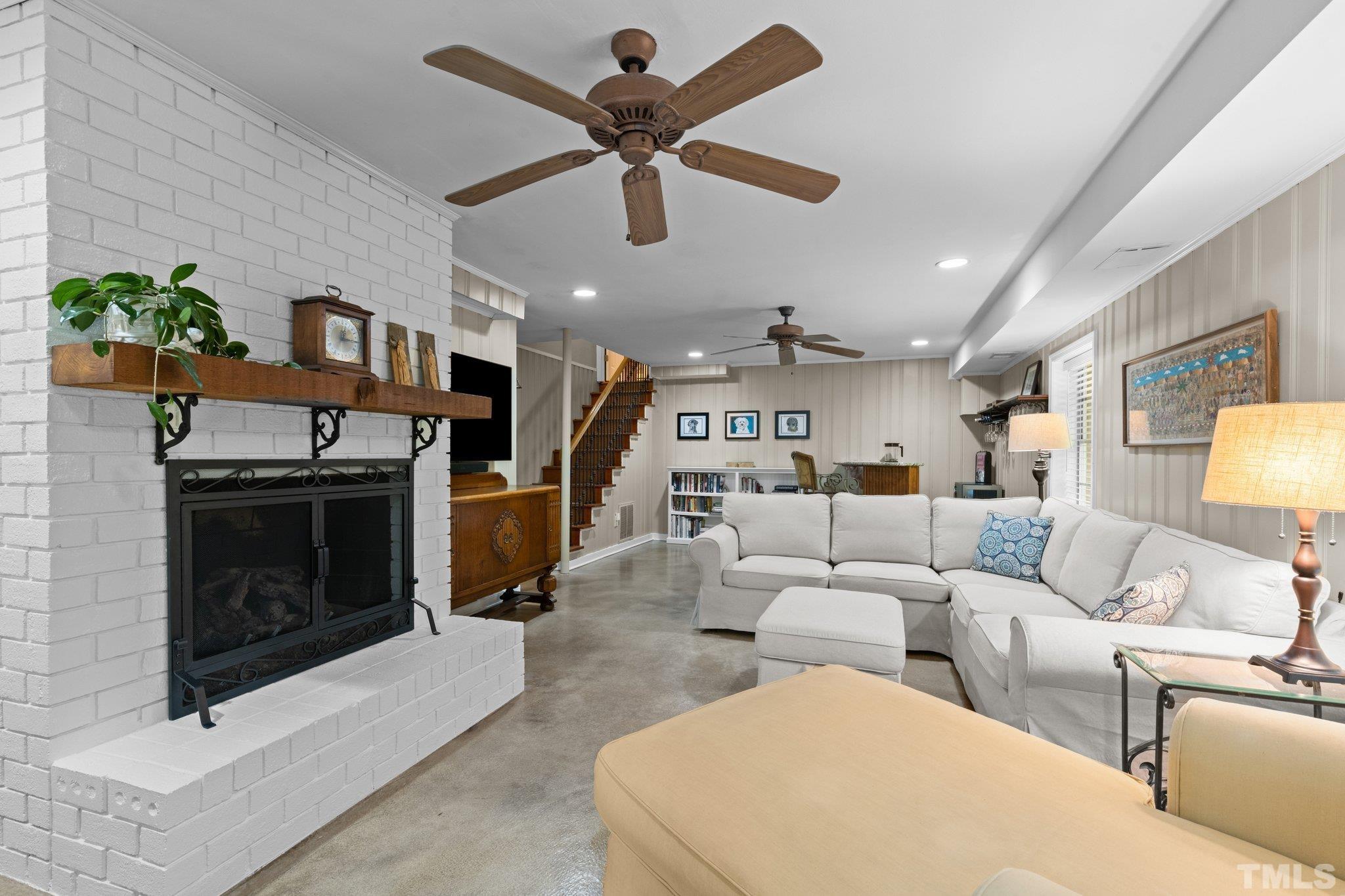4116 Spruce Drive Raleigh, NC 27612 - Photo 17 of 51 a living room with furniture a fireplace and a ceiling fan
