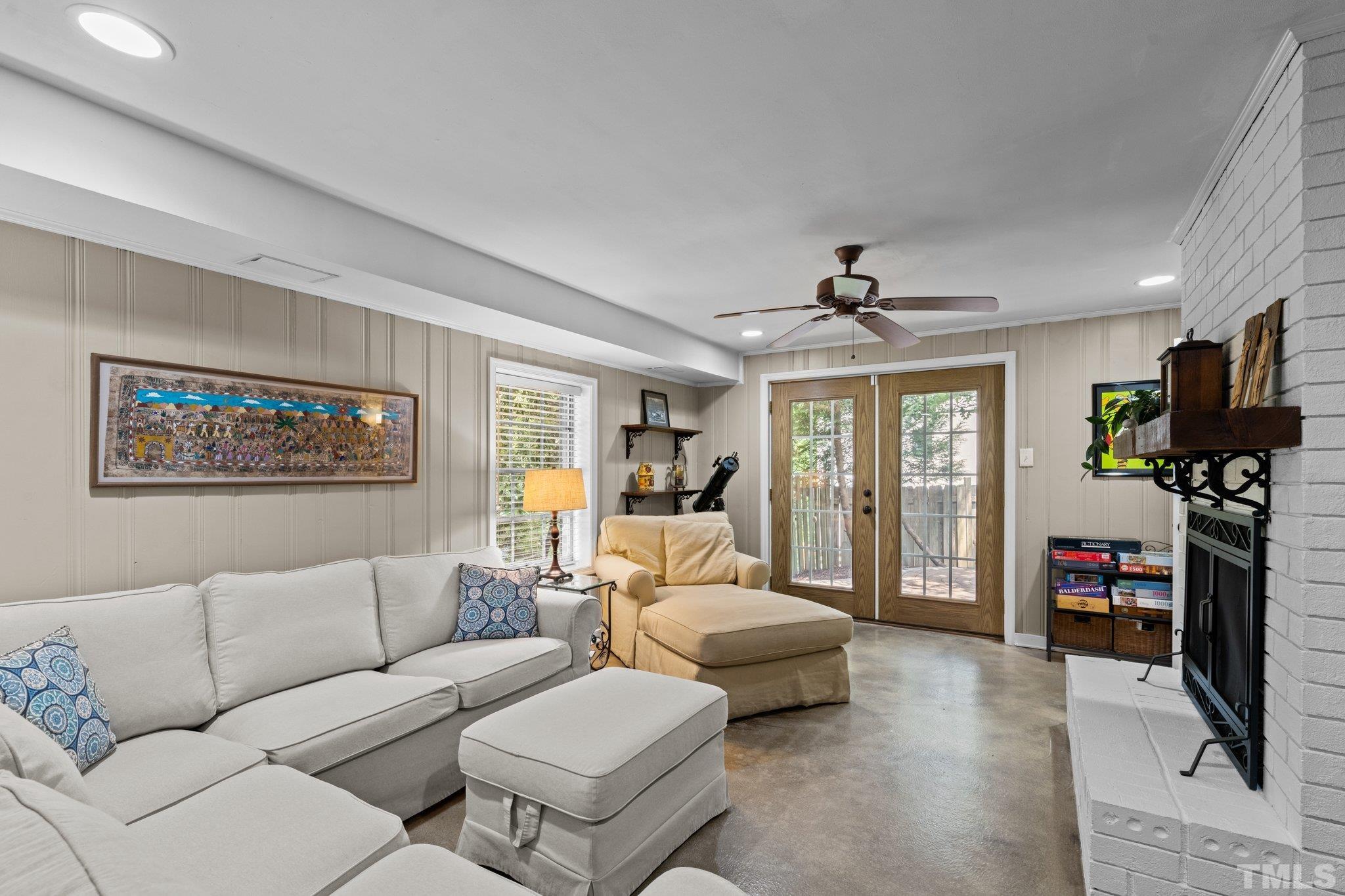 4116 Spruce Drive Raleigh, NC 27612 - Photo 18 of 51 a living room with furniture a flat screen tv and a floor to ceiling window