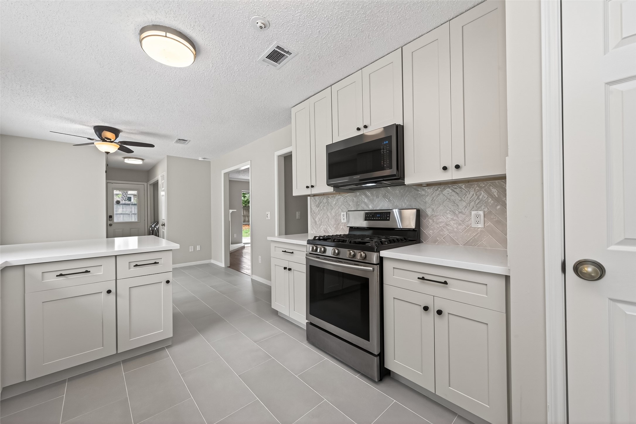 106 Breezy Point Place Spring, TX 77381 - Photo 13 of 37 Dreamy kitchen offers white cabinetry, quartz countertops, stainless steel appliances, and breakfast area.