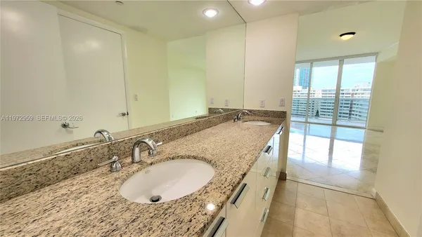 a bathroom with a granite countertop sink and a mirror