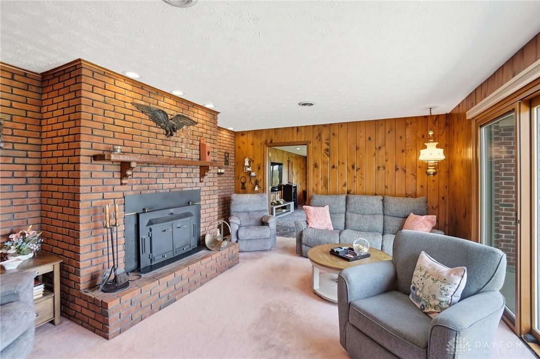 5669 O Neall Road Waynesville, OH 45068 - Photo 28 of 72 This inviting living area features a brick fireplace and warm wood paneling, creating a cozy atmosphere.