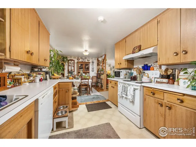 a kitchen with stainless steel appliances kitchen island granite countertop a refrigerator a stove top oven and a sink with cabinets