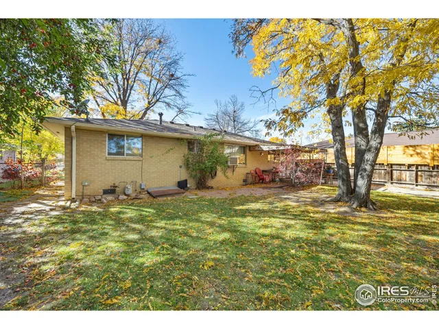 a view of a house with backyard and a tree