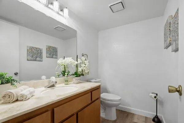 a bathroom with a granite countertop sink mirror and toilet