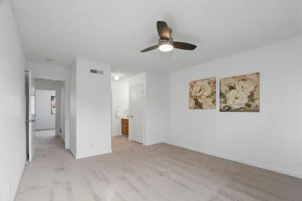 a view of a hallway with a chandelier fan